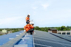 engineer man inspects construction of solar cell panel or photovoltaic cell by electronic device. Industrial Renewable energy of green power. factory worker working on tower roof.