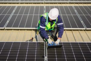 Professional engineers with safety helmet checking solar system at solar power farm, Technicians with solar cell on roof of power factory, Concept of sustainable resources