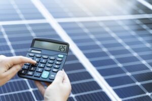 Someone is calculating the savings of use a solar panel system with a calculator